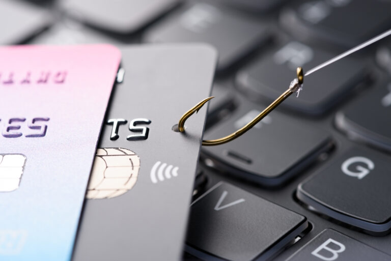 Credit Card On Fishing Hook Pulled From Stack On Keyboard