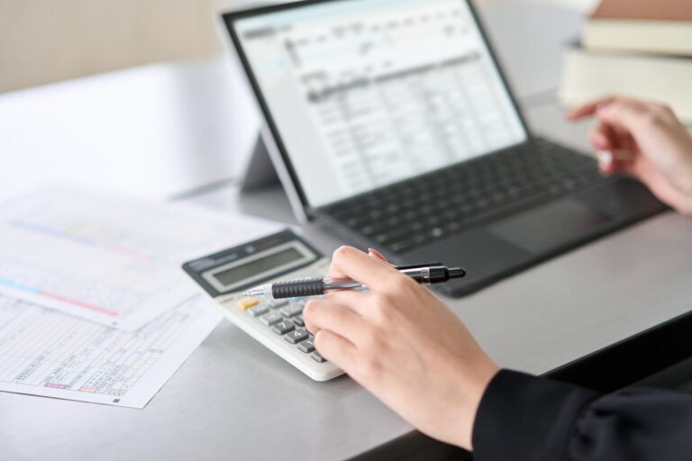 Asian Woman Entering Journal Entries In Accounting Software