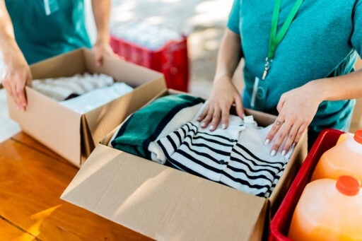 Close Up Of Volunteer Organizing Donation Boxes
